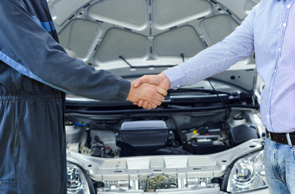 car mechanic and customer shaking hands